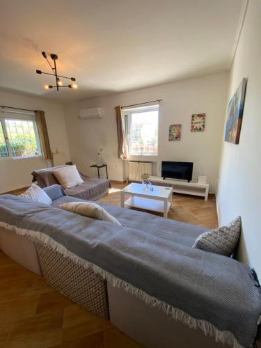 a living room with a large bed and a couch at PATIMA Chalandri House in Athens