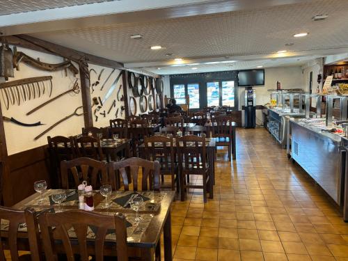 a restaurant with wooden tables and chairs and a counter at Hotel Avanti in Pas de la Casa