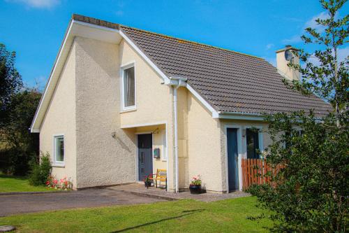 a white brick house with a porch at Dunmore Villas Holiday Home No 1 by Trident Holiday Homes in Dunmore East