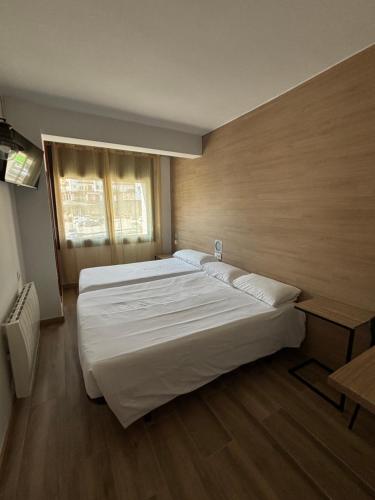 a bedroom with a large white bed and a window at Hotel Avanti in Pas de la Casa