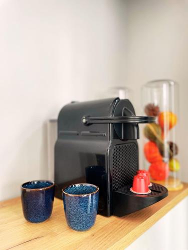 a coffee maker and three blue cups on a shelf at Hotel Plantage in Amsterdam