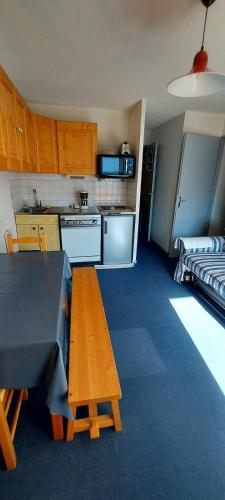 une petite cuisine avec une table et un canapé dans l'établissement Appartement au pied des pistes !, à Le Haut-Breda