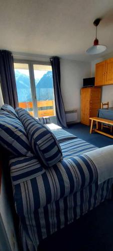 une chambre avec un lit et une grande fenêtre dans l'établissement Appartement au pied des pistes !, à Le Haut-Breda