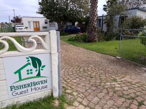 a sign for a guest house in a driveway at Fisherhaven Guest House in Hermanus