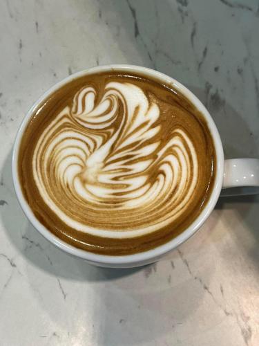 a cup of coffee with a swirl in it at Alona Garden Suites in Panglao