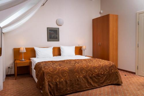 a bedroom with a bed and a wooden cabinet at Mabre Residence in Vilnius