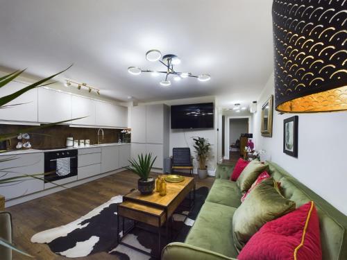 a living room with a green couch and a table at Islington Lux garden flat moments to tube in London