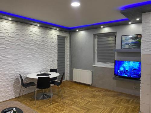 a dining room with a table and a tv at Crystal Apartman Obrenovac in Obrenovac