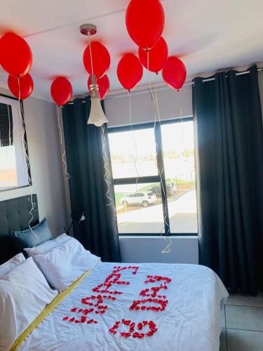 a bedroom with red balloons hanging from the ceiling at The Lagoon Exquisite Apartments in Pretoria