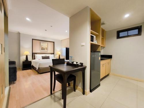 a bedroom with a bed and a desk in a room at The Key Bangkok Hotel in Bangkok