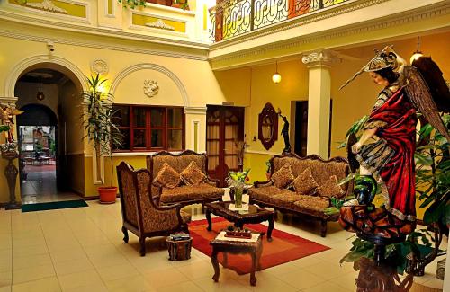 a living room filled with furniture and a statue of a man at San Marino Royal Hotel in Sucre