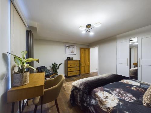 a bedroom with a bed and a desk and a table at Islington Lux garden flat moments to tube in London