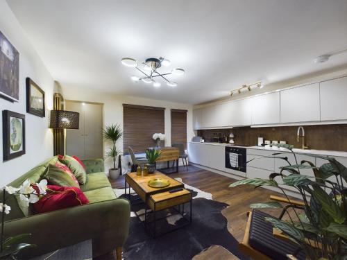 a living room with a couch and a kitchen at Islington Lux garden flat moments to tube in London