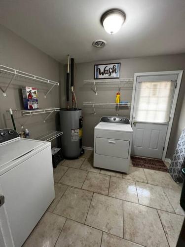 a kitchen with a sink and a refrigerator and a door at Modern 3 Bedroom Ranch House in Newark