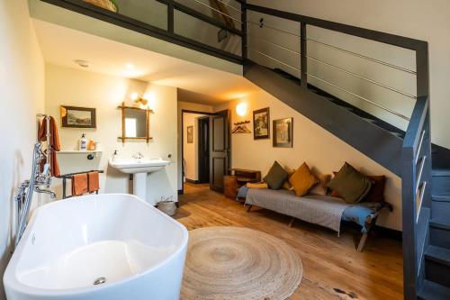 La salle de bains est pourvue d'une baignoire, d'un lavabo et d'un canapé. dans l'établissement Chalet Baron, à 15 min de Bordeaux, à Lormont