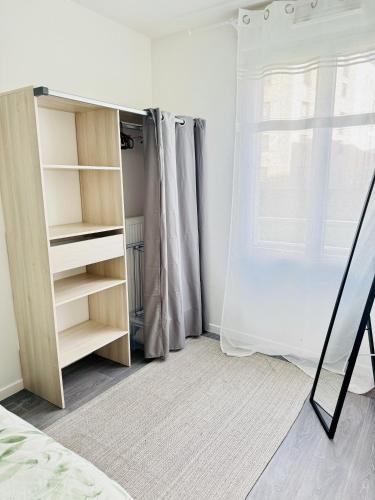 - une chambre avec une étagère et une fenêtre dans l'établissement Moderne Cosy T2 à Évry, à Étiolles