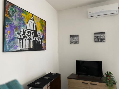 a living room with a tv and a painting on the wall at Pisana 247 St Peter in Rome