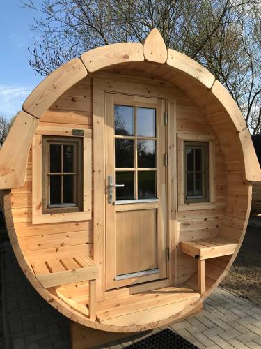 a large wooden sauna with a large wooden door at Star Camp Cosa, Ferienwohnungen, Camping, Schlaffässer in Friedland