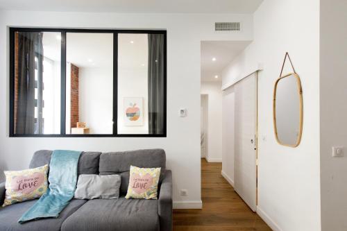un salon avec un canapé et un miroir dans l'établissement L'Elégant YourHostHelper, à Cannes