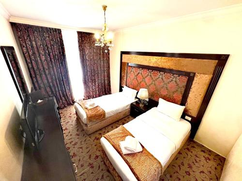 Postel nebo postele na pokoji v ubytování Queens Suite Hotel