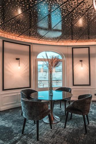 Un comedor con mesa y sillas en Hôtel Carlton Lille, en Lille