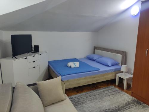 a small bedroom with a bed and a couch at Sunset Apartment in Smederevo
