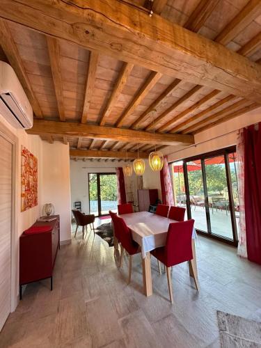 a dining room with a table and red chairs at Villa Ustoma in Sorano
