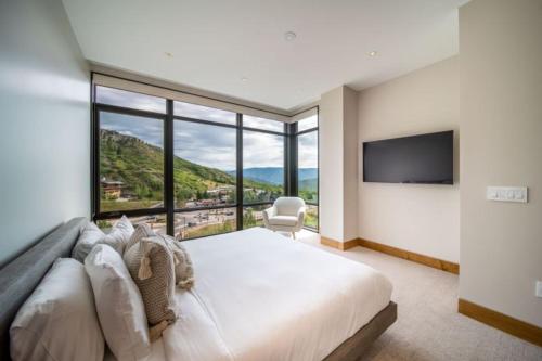 a bedroom with a large bed and a large window at One Snowmass West 503 by Snowmass Mountain Lodging in Snowmass