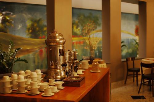 a chess set on a wooden table with cups at Hotel Nacional Inn Araxá Previdência in Araxá
