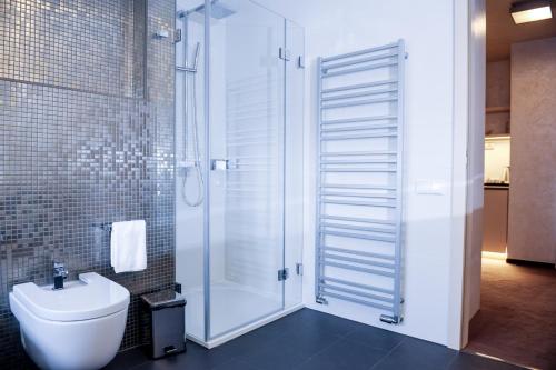 a bathroom with a shower with a toilet and a sink at Myo Hotel Mysterius in Prague