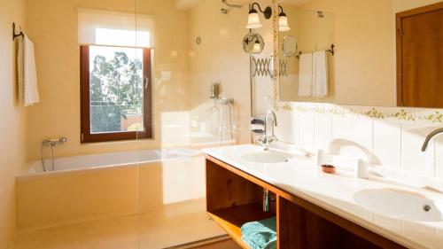 a bathroom with two sinks and a bath tub at Atrio in Estreito da Calheta