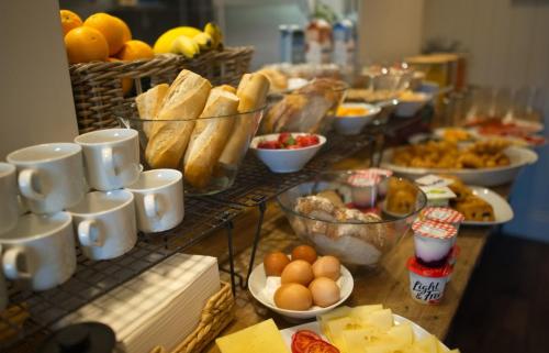 a buffet of food with eggs bread and other foods at The CLOUD Brockenhurst B&B in Brockenhurst