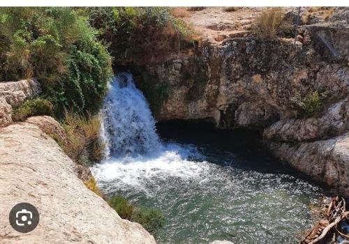 a waterfall on the side of a rocky river at Appartement, vue sur l’étang, proche aéroport. in Vitrolles