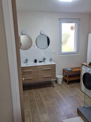 a bathroom with a sink and two mirrors at Appartement, vue sur l’étang, proche aéroport. in Vitrolles