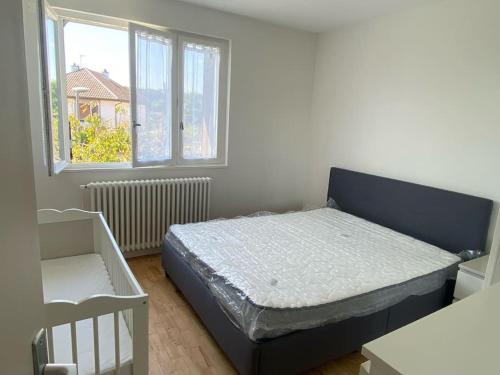 une petite chambre avec un lit et une fenêtre dans l'établissement Campagne à la Ville, à Montbéliard