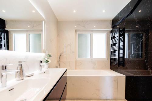 une salle de bain blanche avec une baignoire et un lavabo dans l'établissement Great 3bedrooms 100m from Croisette, à Cannes