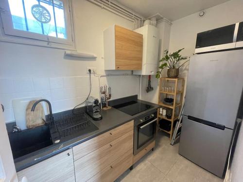 une cuisine avec un évier et un réfrigérateur dans l'établissement Lovely 1BR appartment near Paris, à Boulogne-Billancourt