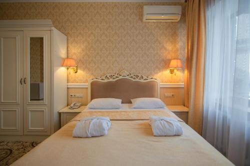 a bedroom with two white pillows on a bed at Royal Olympic Hotel in Kyiv