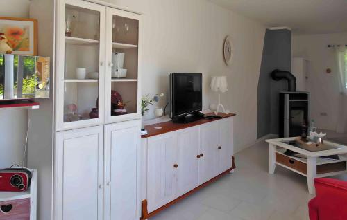 a living room with white cabinets and a tv at Lassan, Ferienwohnung zum Peenestrom in Lassan