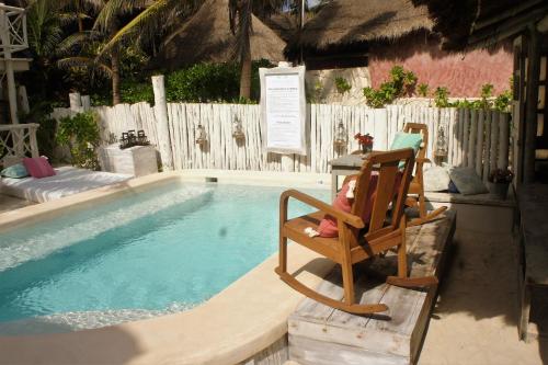 a child sitting in a chair next to a swimming pool at Punta Piedra Beach Posada in Tulum