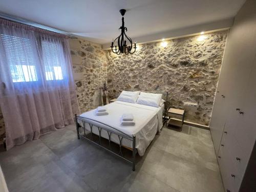 a bedroom with a bed and a stone wall at Polis Villa Rethymnon , Crete in Kálivos