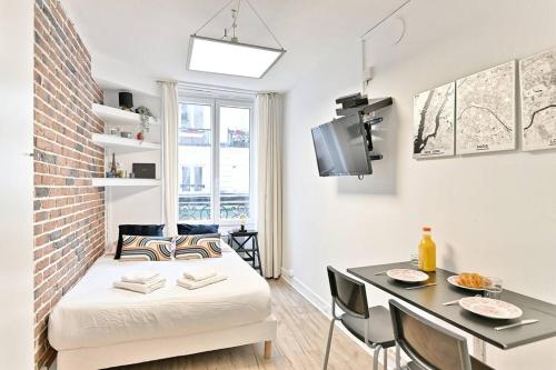 Ce petit appartement comprend un lit et une table à manger. dans l'établissement Petit studio confortable et central #marais - II, à Paris