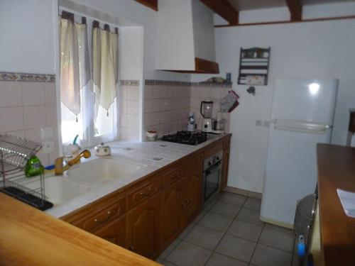 a kitchen with a sink and a stove at location thezacaise in Thézac