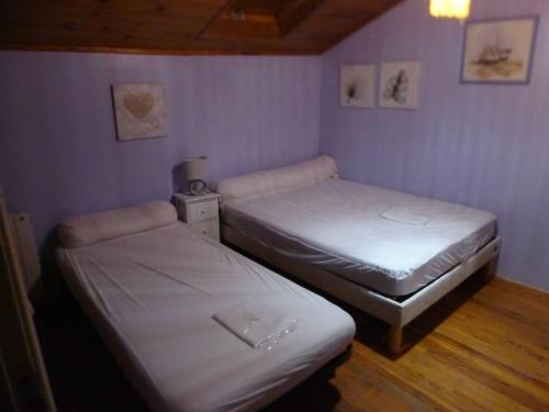 two beds in a room with purple walls at location thezacaise in Thézac