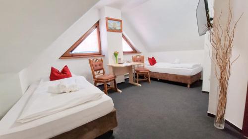 a room with two beds and a table and chairs at Brasserka in Nitra