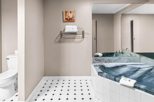 a bathroom with a blue tub and a toilet at Red Roof Inn & Suites Lexington - Hamburg in Lexington