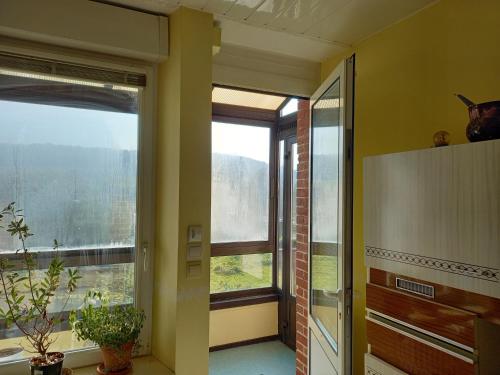a hallway with two large windows in a room at La locomotive by La BB12087 in Nouvion-sur-Meuse