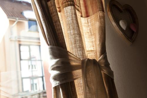 a curtain on a window that is tied up at Brit Hotel Bristol Montbéliard Centre in Montbéliard
