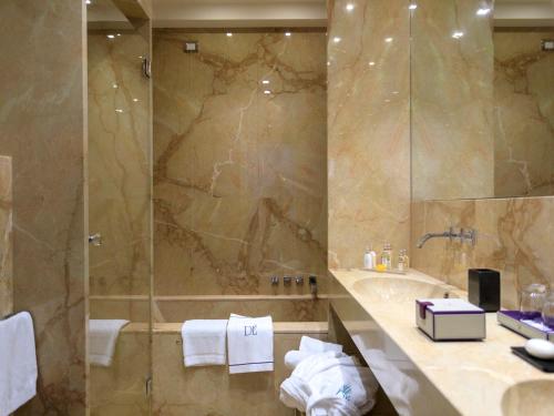 a bathroom with a shower and a sink and a tub at Grand Hotel Des Etrangers in Siracusa