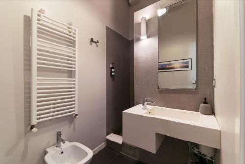 łazienka z umywalką, toaletą i lustrem w obiekcie B&B Parigi w Bolonii